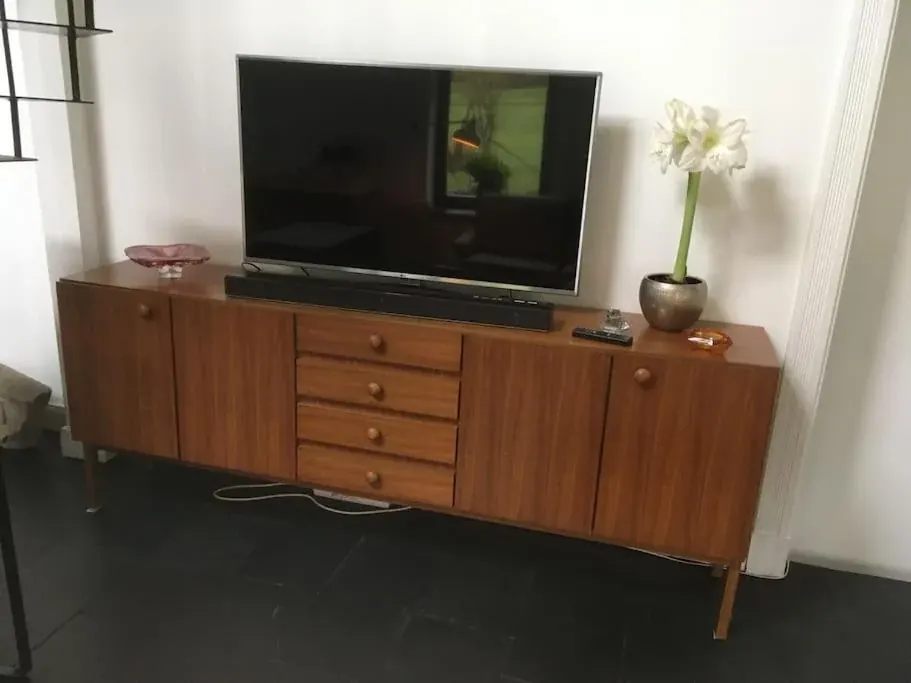 Wohnbereich im Bauernhaus mit TV und hölzernem Sideboard